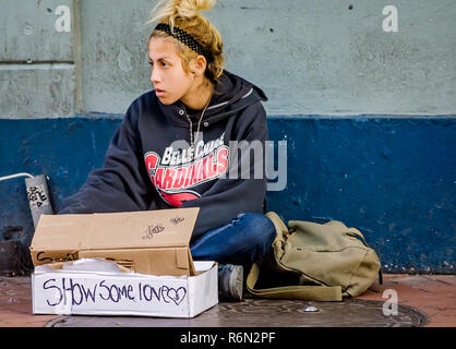 Una giovane ragazza senzatetto panhandles su Bourbon Street, nov. 15, 2015, New Orleans, in Louisiana. Foto Stock