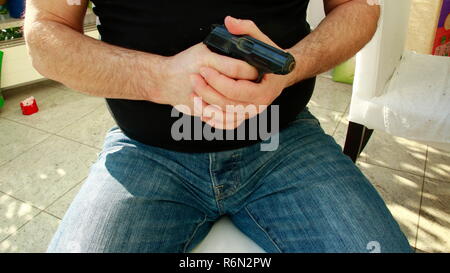 Mani tenendo una pistola nelle loro mani Foto Stock