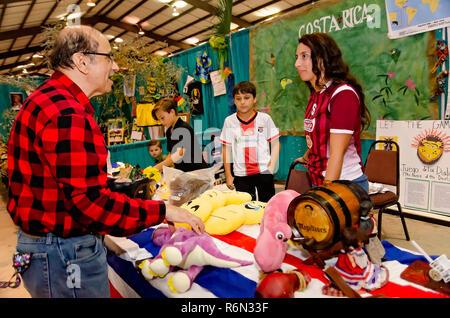 Un uomo acquista un peluche souvenir da una Costa Rican produttore presso La trentaquattresima Mobile annuale Festival Internazionale, nov. 17, 2018 in Mobile, Alabama. Th Foto Stock