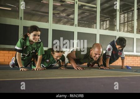 DARWIN Australia - STATI UNITI Il personale marino Sgt. Il Bret Daneker, plotone sergente, azienda I, 3° Battaglione, 4° Reggimento Marini, 1° Divisione Marine, Marine forza rotazionale di Darwin, non Marine Corps Push-Ups con gli studenti nel corso di un evento di volontariato, 31 maggio 2017. Lo stesso gruppo di Marines continuerà la visita e guida gli studenti durante tutto il loro tempo in Darwin. I marines si sono impegnati a servire la comunità locale e continuerà ad avere un impatto quando disponibile. Foto Stock
