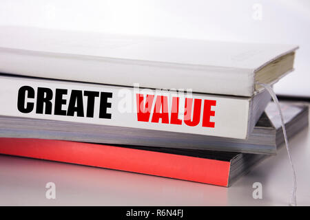 La scrittura di un testo che mostra la creazione di valore. Il concetto di business per creare motivazione scritta sul libro su sfondo bianco. Foto Stock