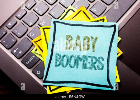 Mano concettuale di scrittura di testo Didascalia ispirazione che mostra i baby boomer. Il concetto di business per la generazione di dati demografici scritto su una nota adesiva carta sulla tastiera scuro dello sfondo. Foto Stock