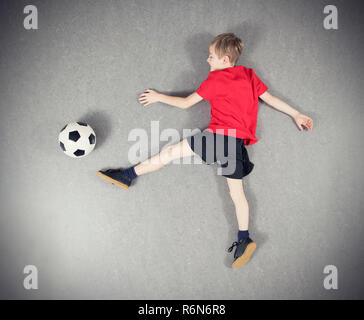 Da ragazzo sopra la riproduzione di pallone da calcio Foto Stock