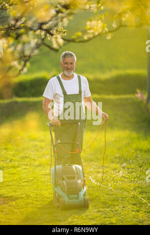 Ritratto di uomo senior di giardinaggio, prendersi cura della sua bella frutteto, ejoying attivamente il suo pensionamento Foto Stock