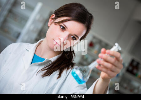 Giovani ricercatori di sesso femminile di effettuare esperimenti in laboratorio (SHALLOW DOF dai toni di colore immagine) Foto Stock