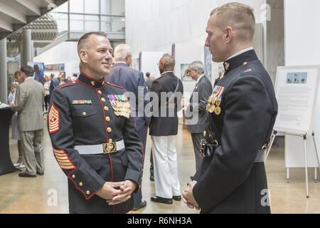 Stati Uniti Marine Corps Sgt. Il Mag. Matthew Hackett, sergente maggiore della caserma marini Washington, parla con il cap. Christopher S. Karwacki, piani officer per i piani, politiche e operazioni, durante una parata di tramonto accoglienza presso le donne in servizio militare per l'America Memorial, Arlington, Virginia, 30 maggio 2017. Sunset parate sono tenuti come mezzo di onorare gli alti funzionari, illustri cittadini e sostenitori del Marine Corps. Foto Stock