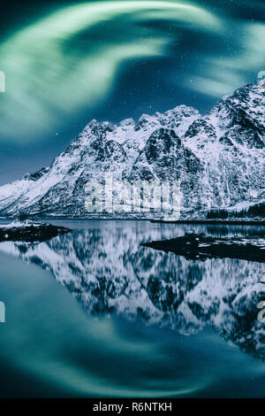 Luci del nord, Aurora Boreale in isole Lofoten in Norvegia. Notte incredibile paesaggio invernale con luci polari e cielo stellato sopra la gamma della montagna Foto Stock