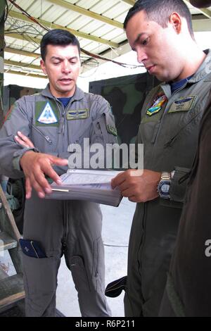 Colombiano di Air Force Lt. Col. Jorge Ordonez (sinistra) e Colombian Air Force Capt, Rodrigo Nunez guardare oltre il controllo a terra di intercettare i manuali di addestramento al Georgia Air National Guard 117Air Control Squadron a Hunter Army Airfield a Savannah, Georgia 30 maggio-giugno 2, 2017 durante un membro del programma di partenariato impegno con la Carolina del Sud la Guardia Nazionale. Foto Stock