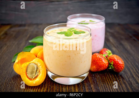 Frullato di albicocca e fragola sul bordo scuro Foto Stock