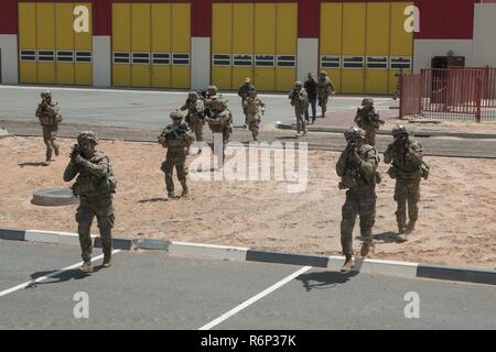 Fanti e della cavalleria scout dal 3° Battaglione, 8 reggimento di cavalleria, 3° Brigata corazzate contro la squadra, 1° Divisione di cavalleria eseguire fino a finti violato le mura della città durante un esercizio di partenariato in Asia sud-ovest. Durante l'esercizio, i soldati hanno cancellato le stanze ed edifici, somministrati tactical combat casualty care, condotta casualty evacuazione e la condotta delle operazioni di stabilizzazione. Foto Stock