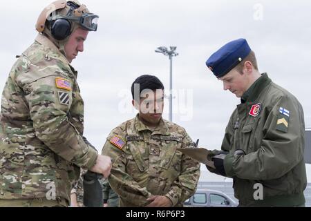 Da soldati e società, 3-10 Supporto generale del battaglione di aviazione, decimo combattere la Brigata Aerea, gestire la fatturazione del combustibile a un finlandese Air Force F-18/A Hornet jet membro dell'equipaggio a Lielvarde Air Base, Lettonia, il 18 maggio. Il getto e la troupe ha completato con successo un programma di test della base della striscia di atterraggio e funzioni di frenatura, la certificazione per l'utilizzo da parte di altre forze della NATO, getti in futuro. Foto Stock