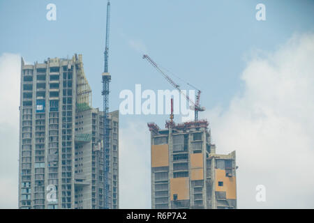 Interno posto per molti alti edifici in costruzione e gru sotto un cielo blu Foto Stock