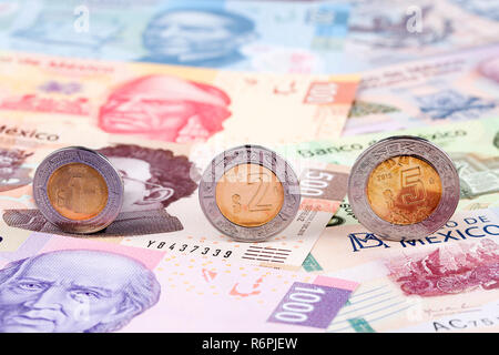 Peso messicano monete sullo sfondo delle banconote Foto Stock