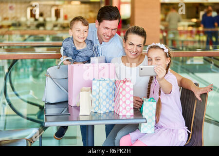 Ragazzina prende un autoritratto della famiglia nel centro commerciale Foto Stock