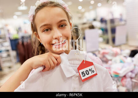 Ragazza acquista shirt durante la vendita in azione una boutique nel centro commerciale Foto Stock