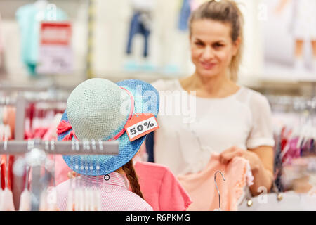 Donna e bambino in hat. Shopping durante una azione di vendita Foto Stock