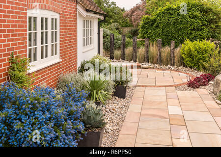 Costiera paesaggistico giardino di ghiaia con pavimentazione e esterno in mattoni di Hampshire Mill House Foto Stock