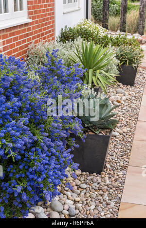 Costiera paesaggistico giardino di ghiaia con pavimentazione e esterno in mattoni di Hampshire Mill House Foto Stock