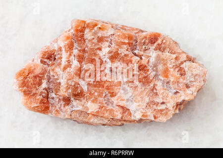 Ruvida pegmatite rosa pietra su bianco Foto Stock