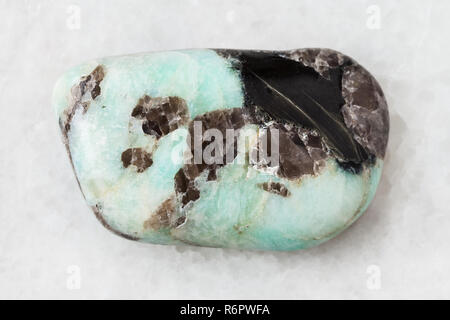 Burattati pietra Pegmatite su bianco Foto Stock