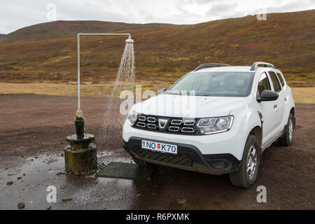 Dacia Duster 4x4 affitto Noleggio auto presso il gabinetto esterno e primavera calda doccia dalla geotermia al vulcano Krafla nei pressi del Lago Myvatn, Islanda Foto Stock