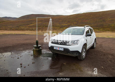 Dacia Duster 4x4 affitto Noleggio auto presso il gabinetto esterno e primavera calda doccia dalla geotermia al vulcano Krafla nei pressi del Lago Myvatn, Islanda Foto Stock