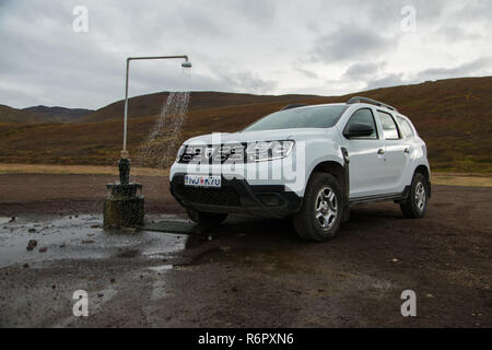 Dacia Duster 4x4 affitto Noleggio auto presso il gabinetto esterno e primavera calda doccia dalla geotermia al vulcano Krafla nei pressi del Lago Myvatn, Islanda Foto Stock