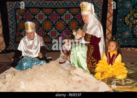 Il kazako donne la battitura e la filatura della lana, kazako villaggio etnografico Aul Gunny, Talgar città, Almaty in Kazakistan e in Asia Centrale, Asia, per contatti Foto Stock