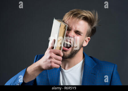 L'uomo faccia sbattere con Libro, motivazione. Imprenditore arrabbiato grida con Libro, conoscenza. La motivazione, potere, successo. La conoscenza, l'informazione, la sapienza. Istruzione, apprendimento, studio. Biblioteca, la letteratura e la lettura. Foto Stock