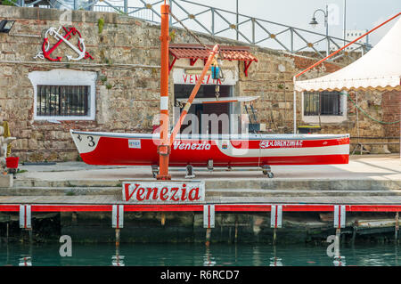 Barca a remi esposti nel quartiere Venezia di Livorno, Toscana, Italia. barca a remi utilizzata per il Palio di Livorno Foto Stock