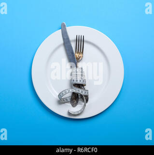 Coltello con una forcella avvolto in un nastro di misurazione Foto Stock