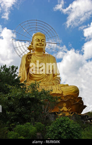 Buddha d'oro su uno sfondo di cielo blu con un alone intorno alla sua testa Foto Stock