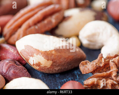 Mix di anacardi, pecan, pinoli, nocciole su blu Foto Stock