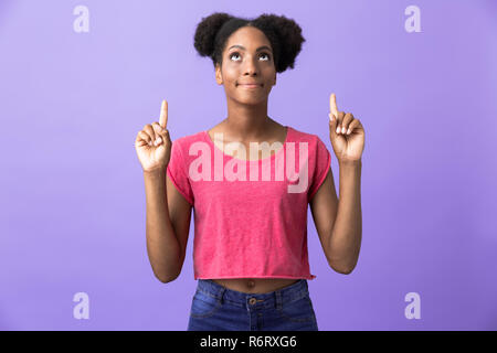 Foto di teen americano africano donna denti rivolti verso l'alto a copyspace isolato su sfondo viola Foto Stock