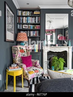 Riutilizzato wingback poltrona con un grande specchio sopra il camino in Richmond home Foto Stock