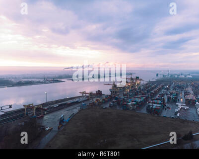 Porto industriale con i contenitori. Overhead drone di filmati di contenitori di spedizione con la rete di trasporto camion. Importazione, esportazione Foto Stock