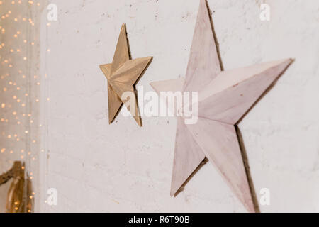 A forma di stella di Natale natale decorazione lampadine cannella stelle sulla pila di neve contro la parete in legno.stella decorativa con lampade su uno sfondo di parete. Moderno grungy interni.Buon Natale e felice anno nuovo. Foto Stock