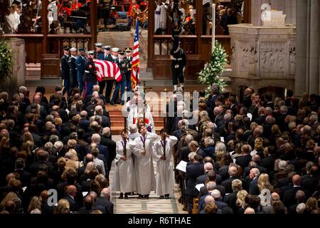 Washington DC, Stati Uniti d'America. 5 dicembre, 2018. I membri del clero episcopale portare la bandiera drappeggiati scrigno di ex presidente George H.W. Bush si è portato giù il corridoio della cattedrale nazionale dopo i funerali di Stato il 5 dicembre 2018 a Washington, DC. Bush, la quarantunesima edizione del presidente, morì nella sua casa di Houston all'età 94. Credito: Planetpix/Alamy Live News Foto Stock