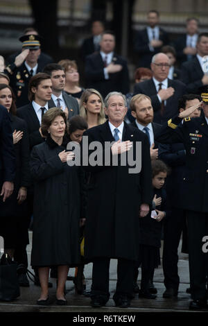 Ex Pres. George W Bush, moglie Laura e gli altri membri della famiglia stand presso l'attenzione come un militare di guardia d'onore porta scrigno di Bush padre, ex Presidente George H.W. Bush, a un funebre prima della sepoltura presso la vicina Biblioteca George Bush Foto Stock