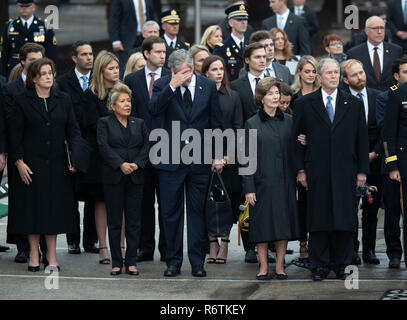 Ex Pres. George W Bush, moglie Laura e gli altri membri della famiglia stand presso l'attenzione come un militare di guardia d'onore porta scrigno di Bush padre, ex Presidente George H.W. Bush, a un funebre prima della sepoltura presso la vicina Biblioteca George Bush Foto Stock