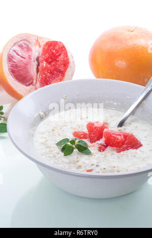 Dolce di farina di avena con fette di pompelmo rosso in un vaso di ceramica Foto Stock