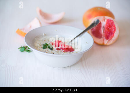 Dolce di farina di avena con fette di pompelmo rosso in un vaso di ceramica Foto Stock