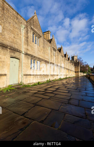 Gli ospizi di carità e di St James chiesa bagnato con pavimentazione in pietra, Chipping Campden, Cotswolds, Gloucestershire, England, Regno Unito, Europa Foto Stock