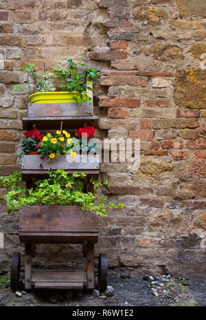 Arredamento da giardino - fiori in vaso su un carrello sulla strada Toscana Foto Stock