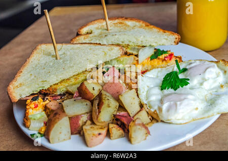 Sandwich con pimiento formaggio, pomodori verdi fritti e pancetta e scalogno aioli servito con patate rosse al sole nella mia pancia in Atlanta, Georgia. Foto Stock