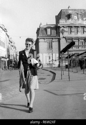 Parigi Francia aprile 1944 donna shopping con baguette di pane. Parigi Francia francese 1940 femminile tempo di guerra occupato Foto Stock