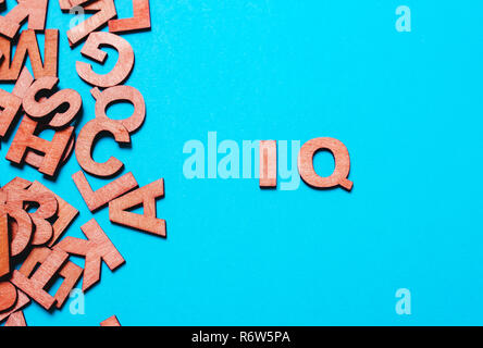 Parola ,sigla IQ di lettere in legno su uno sfondo blu Foto Stock