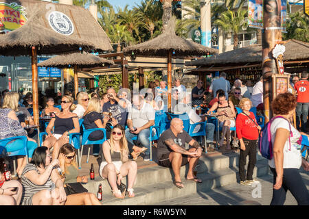 Benidorm, Costa Blanca, Spagna. I bevitori godono di alte temperature invernali al bar Tiki Beach sulla spiaggia di Levante, che è stato rinnovato e riaperto Foto Stock