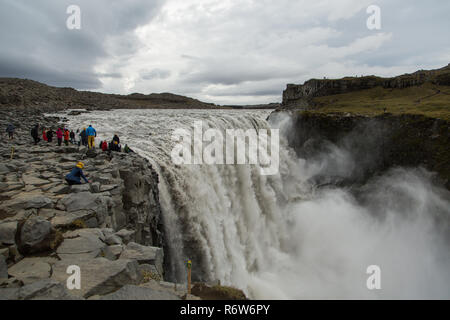 I turisti ottenere pericolosamente vicino al bordo della cascata di Dettifoss in Islanda prendendo selfies e che posano per una foto Foto Stock