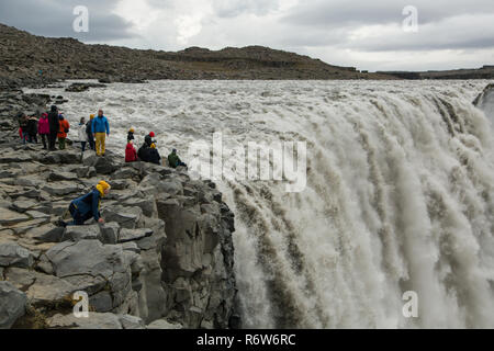 I turisti ottenere pericolosamente vicino al bordo della cascata di Dettifoss in Islanda prendendo selfies e che posano per una foto Foto Stock